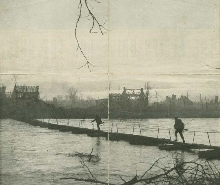 Zwei Alliierte Soldaten überqueren die reißende Rur über eine temporäre Brücke.