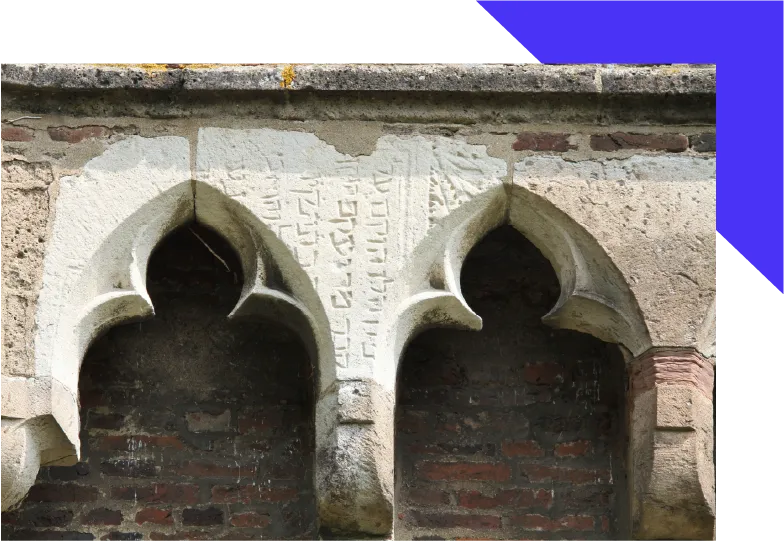 Teil einer alten Mauer mit Inschrift.